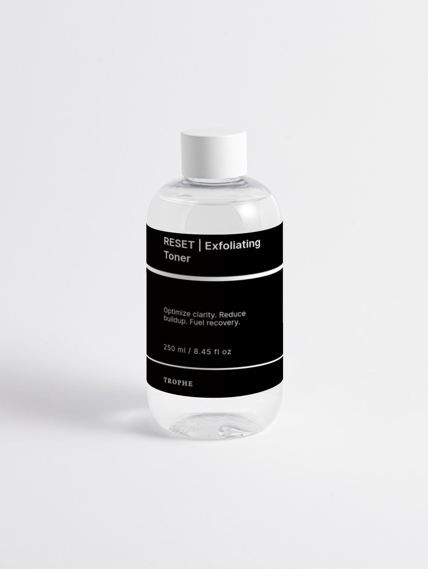 Clear bottle of 'RESET Exfoliating Toner' with a black label on a white background
